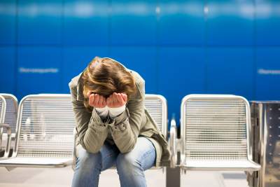 Woman sitting alone with head on hands feeling overwhelmed from worries and feeling nervous