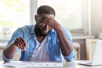 Man stressed out due to his high stress work with hand to forehead